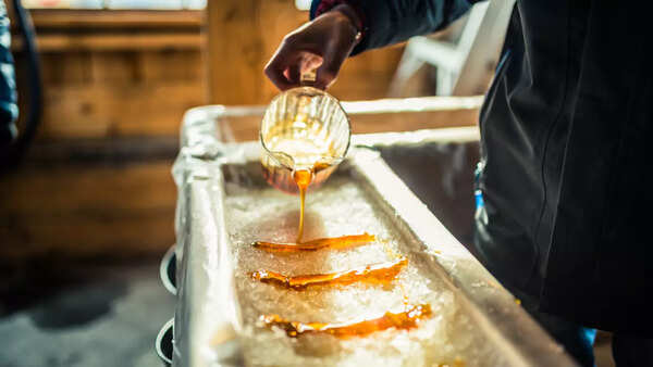 Pouring syrup into a stack of pancakes